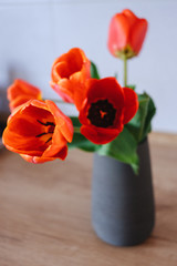 Bouquet of tulips in vase on wooden table