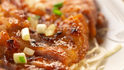 A close up Well-Done Grilled Pork with Spicy Sauce