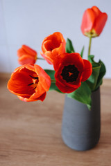 Bouquet of tulips in vase on wooden table