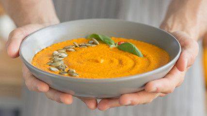 Chef made hot pumpkin soup and bring it in plate