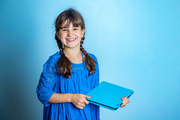 Obraz premium indoor portrait of young child girl with laptop, isolated studio shot, online education