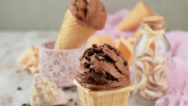 Delicious summer dessert chocolate ice cream in waffle cone. Summer healthy food concept, lactose free. Camera slide down