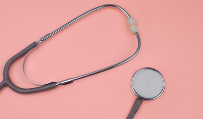 Two part of one single stethoscope isolated on a pink colored background