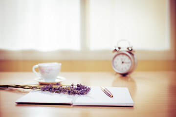 Coronavirus, Covid-19, notebook with lavender and alarm clock on the desk in home office