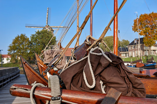 Abstract image of bow of Dutch traditional sailing boat with trees and a windmill in the background