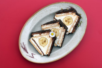 Slices of unbaked dessert in triangle shape made of flat light and dark biscuits