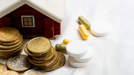 concept of healthcare system recovery for COVID-19 crisis in EU, euro coins stacked and pills on clean and nice white textile fabric.