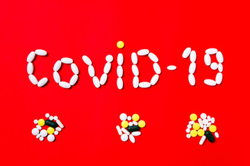 Weapon against COVID-19. Colored pills, tablets and capsules on a red background - history of treatment. Concept of healthcare and medicine, vaccine, prevention of pandemic, epidemic, chronic diseases