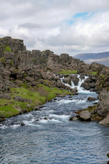 Fototapeta na wymiar The course of the Oexara River among the lava rocks in Thingvellir National park, Iceland.