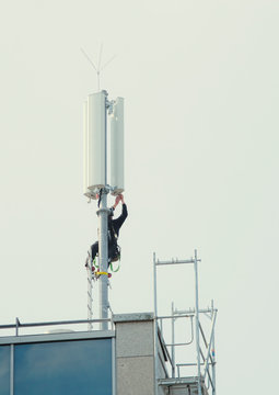 Technician working on a mobile phone mast,base station,transmitter, economy,communication,mobile phone,