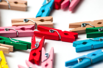 Many decorative colored pegs on white background, macro closeup