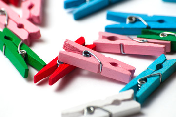 Many decorative colored pegs on white background, macro closeup