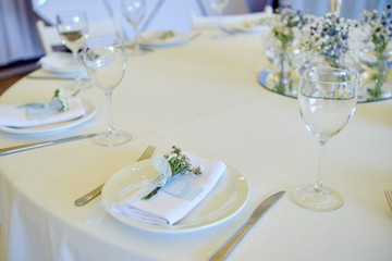 Table set with blank guest card, plate with white napkin and cutlery on table, copy space. Place setting at wedding reception. Table served for wedding banquet in restaurant
