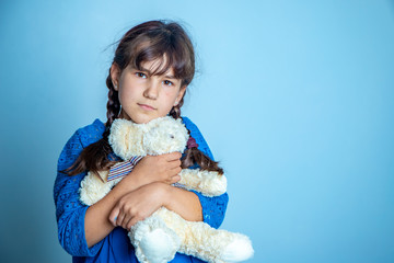indoor portrait of young child girl with teddy bear, isoalted studio shot