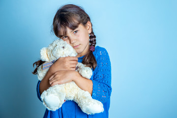 indoor portrait of young child girl with teddy bear, isoalted studio shot