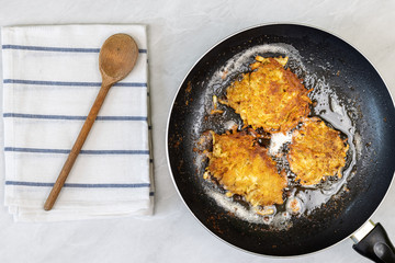Frying grated potatoes pancakes in the frying pan