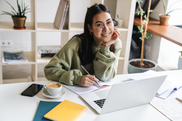 Optimistic young girl student using laptop computer