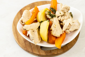 Top view of cooked chicken meat with cooked carrot and potatoes