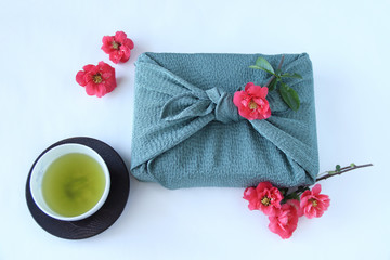 赤いボケの花と風呂敷包みと緑茶