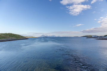 Norwegian fjord and mountains surrounded by clouds, ideal fjord reflection in clear water. selective focus.