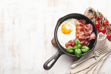 Fried eggs with bacon on white background