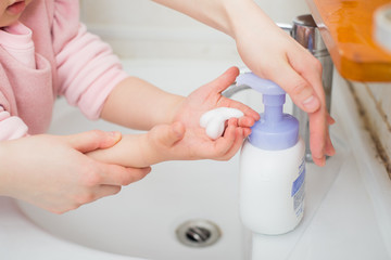 Obraz na płótnie Canvas Children wash their hands with disinfectant foam to maintain health and kill viruses.
