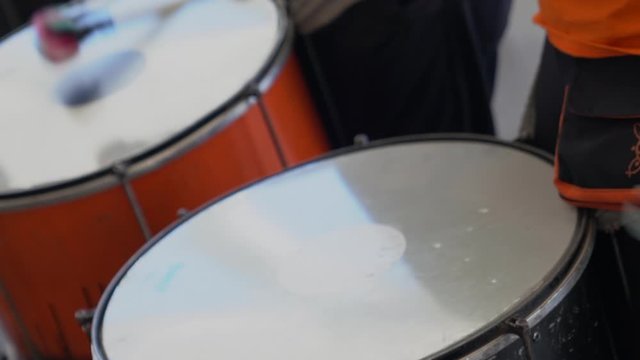 beautiful close up of two drummers as they beat the drums in a high speed display of rhythm and skill in sequence as part of a larger drum troupe out of shot