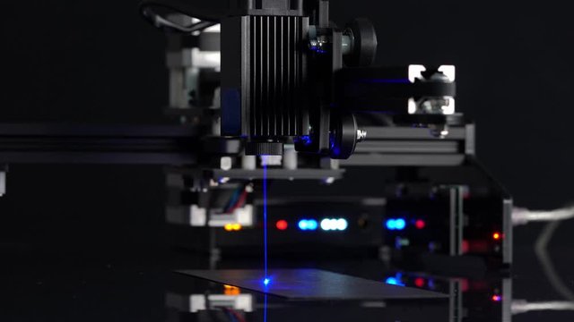 Modern Laser Cutting CNC tool.    Automation High precision laser manufacturing of parts.  Close up computer cnc on dark background.
