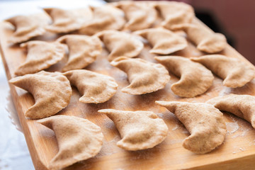cooking healthy food at home. closeup dumplings from rye flour over wooden cutting board