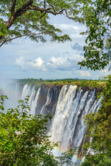 Panorama view with dramatic waterfall Rainbow and clouds at Victoria Falls, Zimbabwe, Zambia....