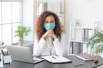 Female lawyer in protective mask working in office