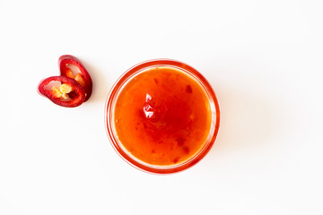 Sweet chili sauce in glass bowl isolated on white background, above. Seasoning and dip