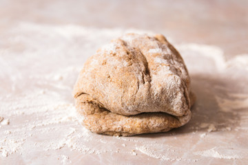 process of baking health bread at home. closeup woman hands kneading dough from rye flour on marble countertop in bright kitchen