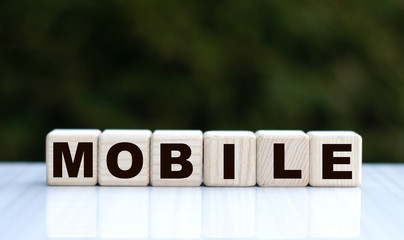 The concept of the word MOBILE on cubes on a beautiful green background