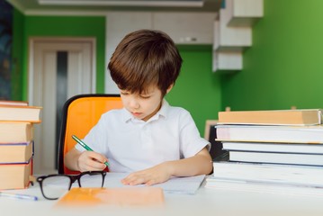 Child doing homework at home. Kids study and learn. Preschooler kid writing and reading. Back to school.