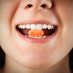 Fototapeta premium magic pill in a woman's teeth. medicine for women. pink tablet close up. cure for all diseases