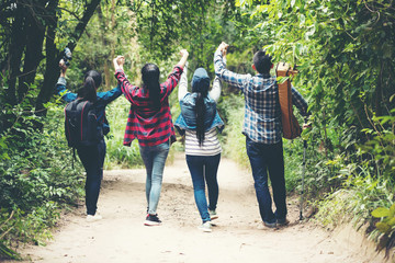 Group backpack people travel and explore adventure in nature. Asian friends and team walking relax for destination leisure landscape forest in summer day. Travel and lifestyle Concept