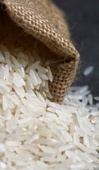 Long grain white  rice close-up on a background of coarse burlap.
