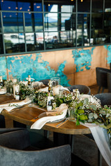 banquet table is decorated with plates, cutlery, glasses, candles and flower arrangements