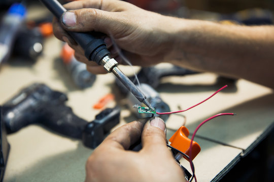 a man in a soldering workshop and is engaged in repair