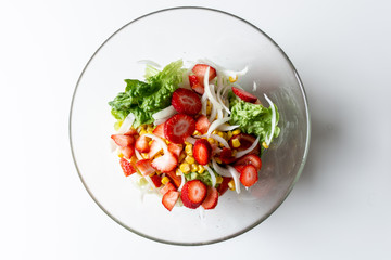 Bowl with delicious vegetable salad on white background, top view
