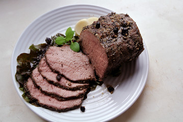 Beef and beef meat in a glass plate. Roast beef in spices. Cooking meat marinating in spices and herbs