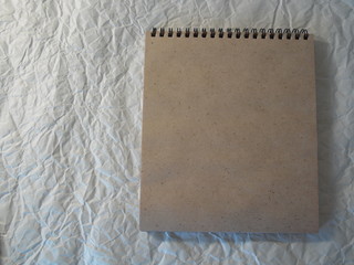 Notepad with craft sheets on a white crumpled background