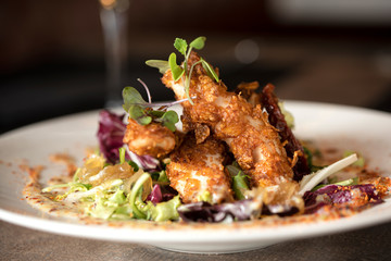 Alitas de pollo fritas con semillas de sésamo y salsa dulce.