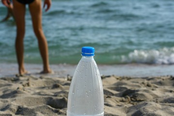 Bottle of water on sandy beach