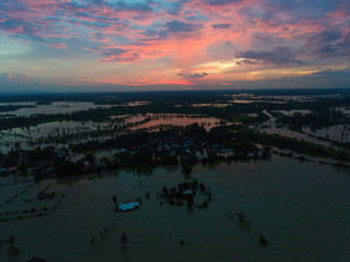 Sakonnakhon, Thailand - August 3, 2017 (Ban kang tha lap village,Kusumal district,Sakonnakhon) : Flood waters overtake a house and rice field in northeast of Thailand from above view by drone
