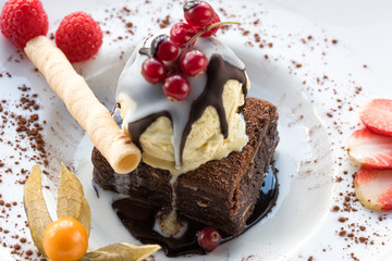 Brownie with nuts, chocolate and syrup and a scoop of ice cream. Petit gateau with ice cream. Petit gateau with ice cream.