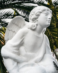 SOCHI, RUSSIA - November 4, 2019: White statue of an angel in a green garden. Angel looking...