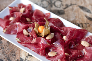 Plato de Jamón Serrano en plato blanco. Restaurante de lujo. Mesa vintage. 