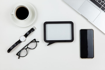 Modern working space, top view. Laptop, coffee, wrist watch, black frame, smartphone, glasses on...